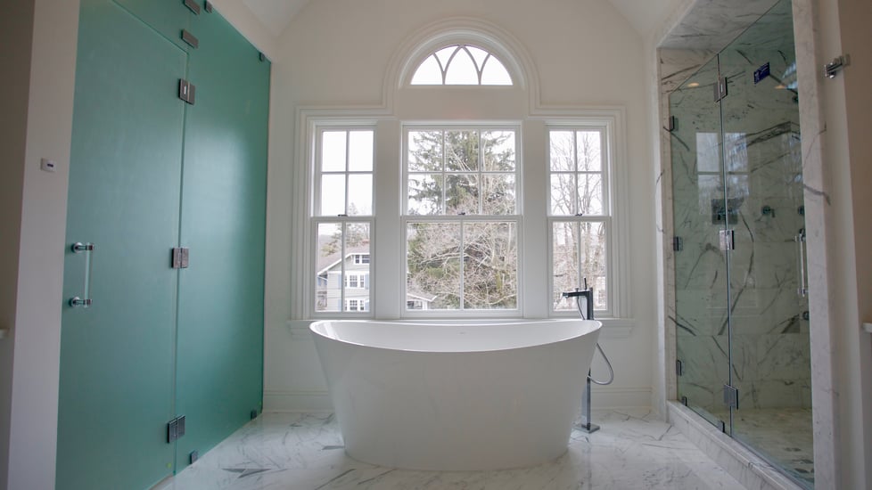 Frameless shower doors and panels for steam room and shower enclosure for a modern, spa feel.